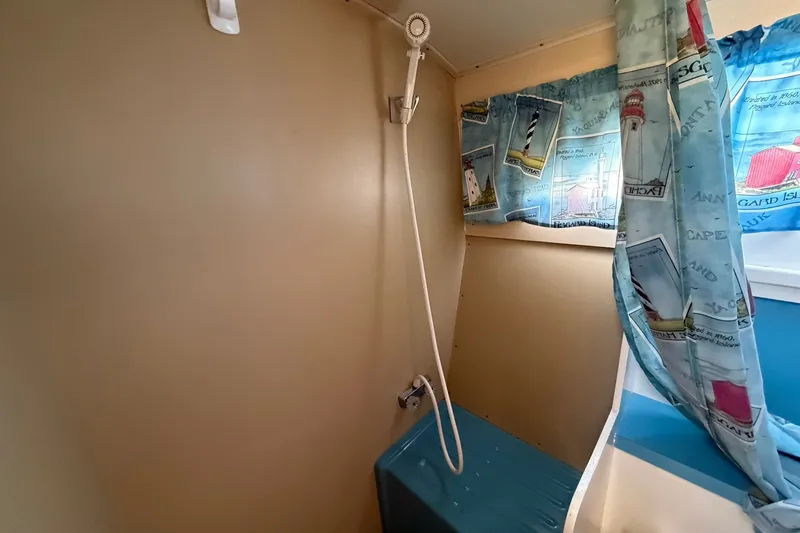 Slide: The Image of 1973 Chris-Craft 31 Sedan Cruiser bathroom with shower and nautical-themed curtains. - 49