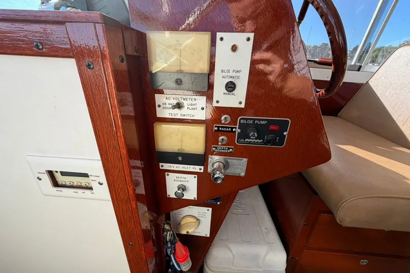 Slide: The Image of 1973 Chris-Craft 31 Sedan Cruiser dashboard with gauges, switches, and bilge pump controls. - 45