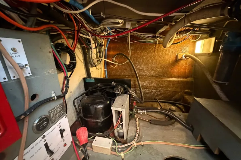 Slide: The Image of Engine room of a 1973 Chris-Craft 31 Sedan Cruiser with wiring and machinery. - 70