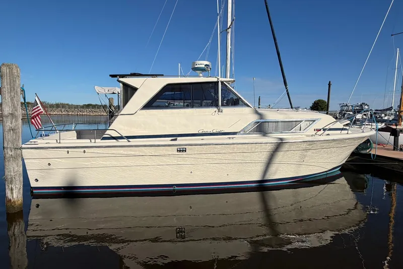 The Image of 1973 Chris-Craft 31 Sedan Cruiser docked at marina under clear blue sky. - 0