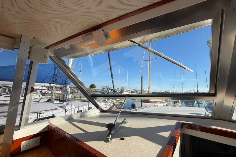 Slide: The Image of Interior view of 1973 Chris-Craft 31 Sedan Cruiser at marina, showcasing window and docked boats. - 60