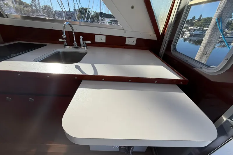 Slide: The Image of Interior of 1973 Chris-Craft 31 Sedan Cruiser with sink and countertop, marina view. - 32