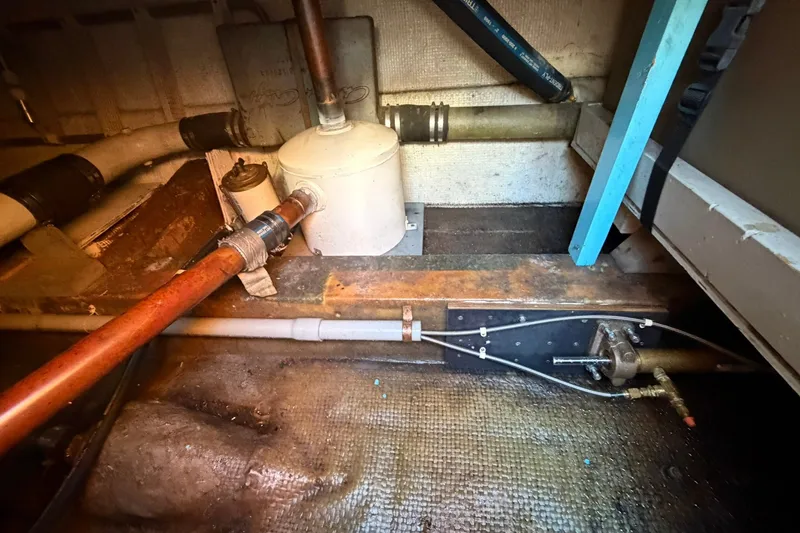 Slide: The Image of Engine room of a 1973 Chris-Craft 31 Sedan Cruiser with visible pipes and components. - 17