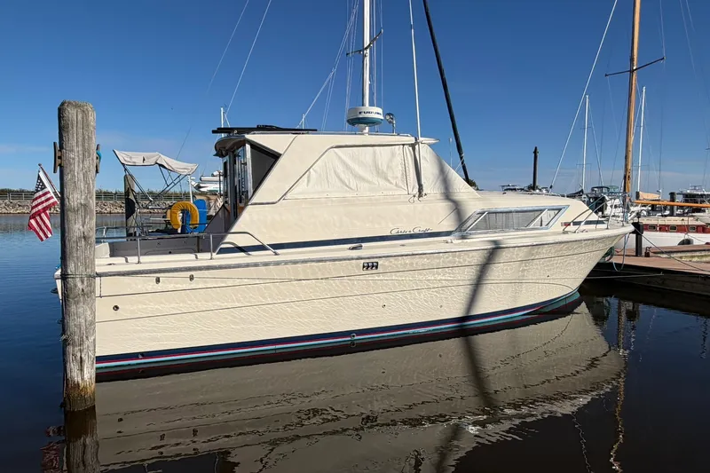 Slide: The Image of 1973 Chris-Craft 31 Sedan Cruiser docked in a marina under clear blue skies. - 6