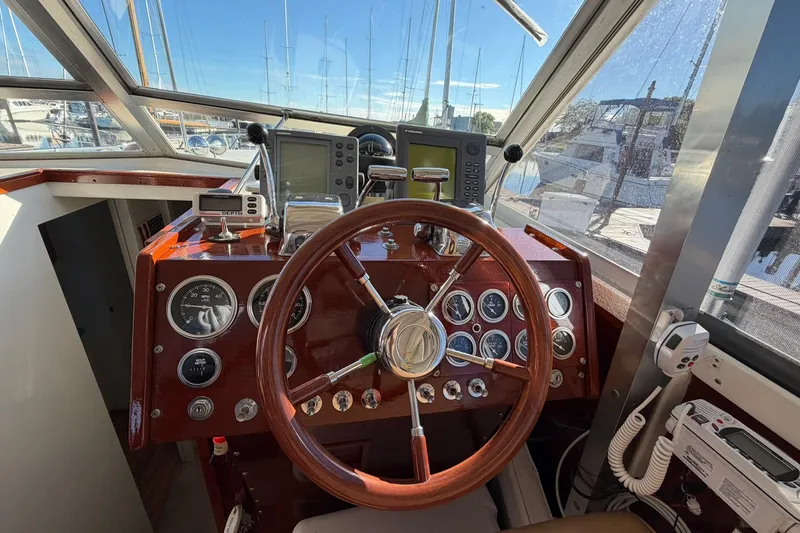 Slide: The Image of 1973 Chris-Craft 31 Sedan Cruiser helm with classic wooden steering wheel and navigation instruments. - 35