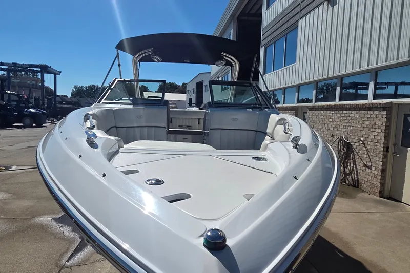 Slide: The Image of 2005 Cobalt 272 boat with sleek design, docked near a building under clear blue sky. - 16