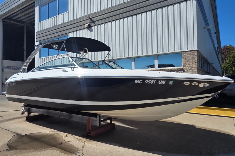 The Image of 2005 Cobalt 272 boat with black hull, docked outside a warehouse. - 0