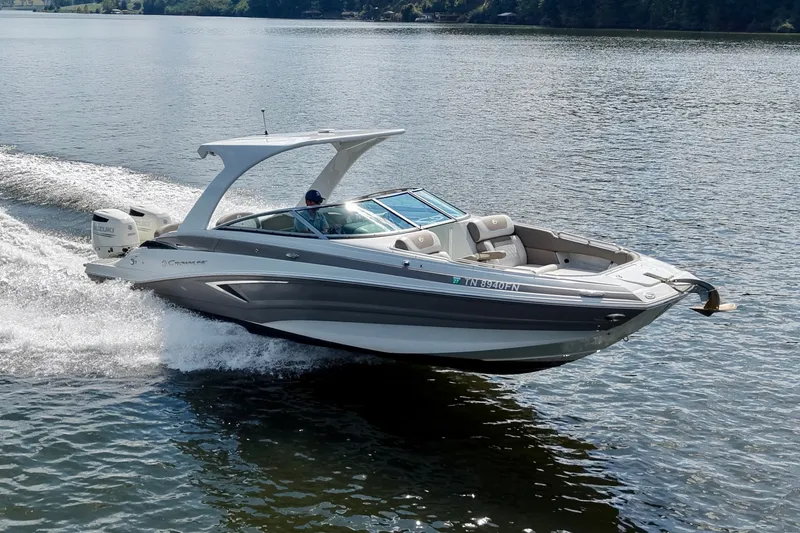 The Image of 2020 Crownline Eclipse E305 XS boat cruising on a serene lake. - 0