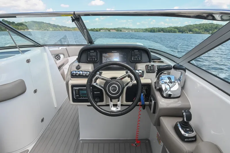 Slide: The Image of 2020 Crownline Eclipse E305 XS boat cockpit with modern controls and scenic lake view. - 39