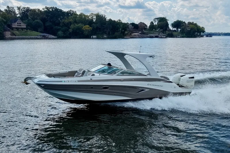 Slide: The Image of 2020 Crownline Eclipse E305 XS boat cruising on a scenic lake. - 55