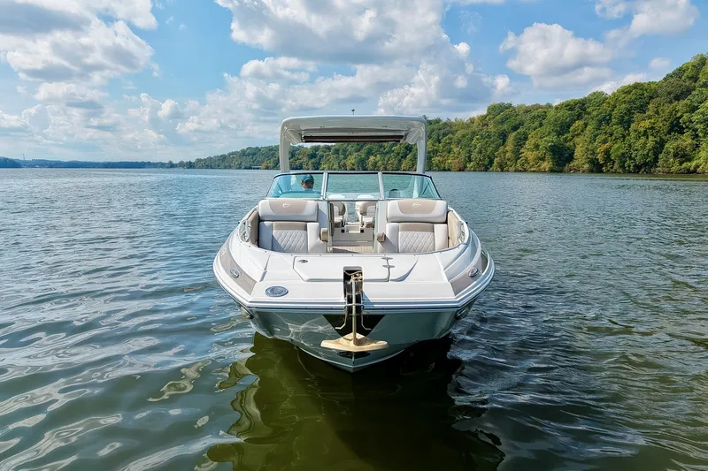 Slide: The Image of 2020 Crownline Eclipse E305 XS boat on a serene lake with lush green shoreline. - 14