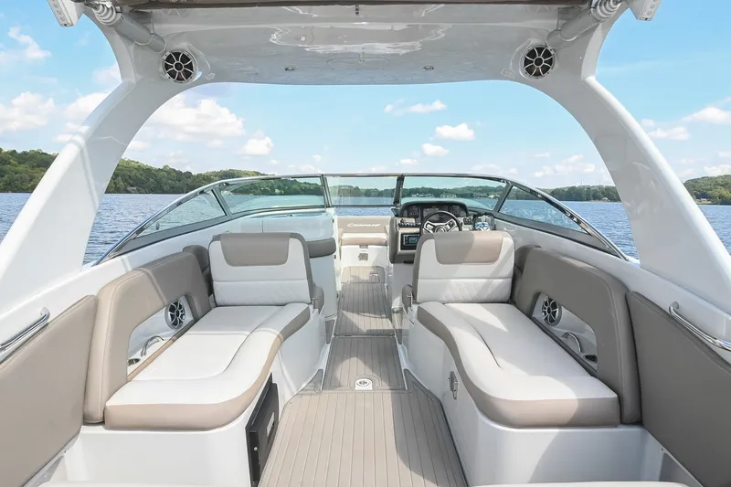 Slide: The Image of 2020 Crownline Eclipse E305 XS boat interior with spacious seating on a serene lake. - 24