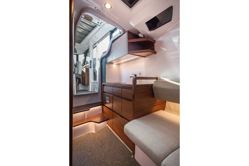 Slide: The Image of Interior of 2027 Axopar 38 XC Cross Cabin, featuring modern wood cabinetry and seating. - 17
