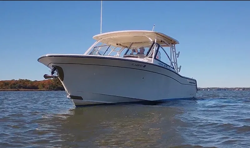 The Image of 2015 Grady-White Freedom 307 on calm water, with clear blue sky in the background. - 0