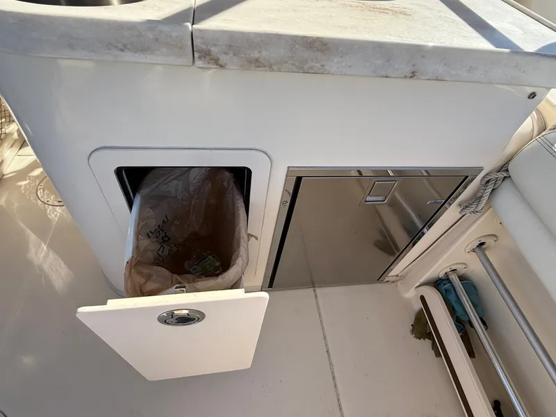 Slide: The Image of The 2015 Grady-White Freedom 307 features a boat galley with a trash bin and cabinet. - 36