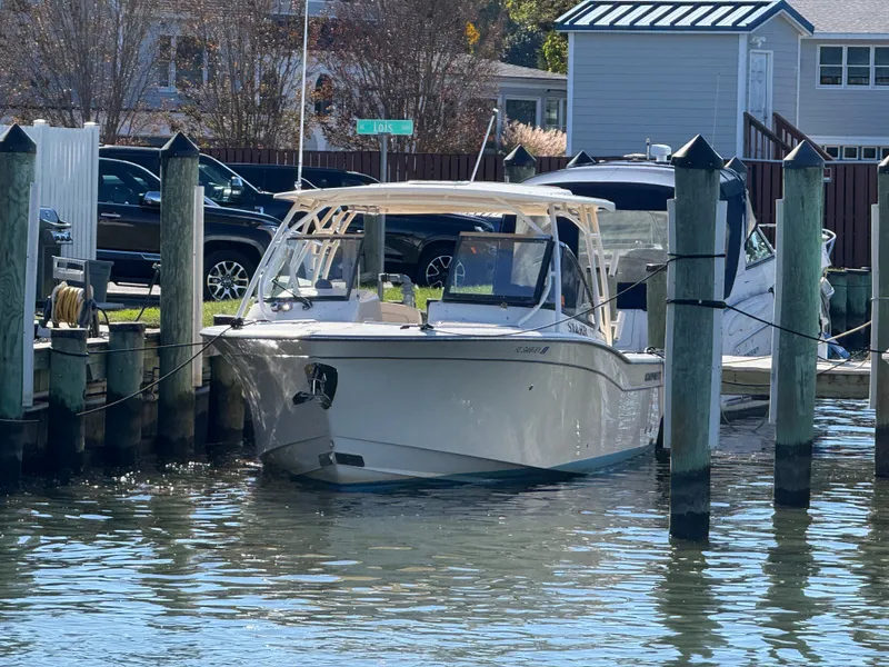 Slide: The Image of A 2015 Grady-White Freedom 307 boat docked. It features an open deck and is surrounded by water. - 3