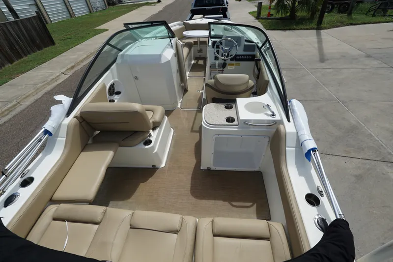 Slide: The Image of 2020 NauticStar 2302 Legacy Dual Console boat interior with beige seating and steering console. - 11