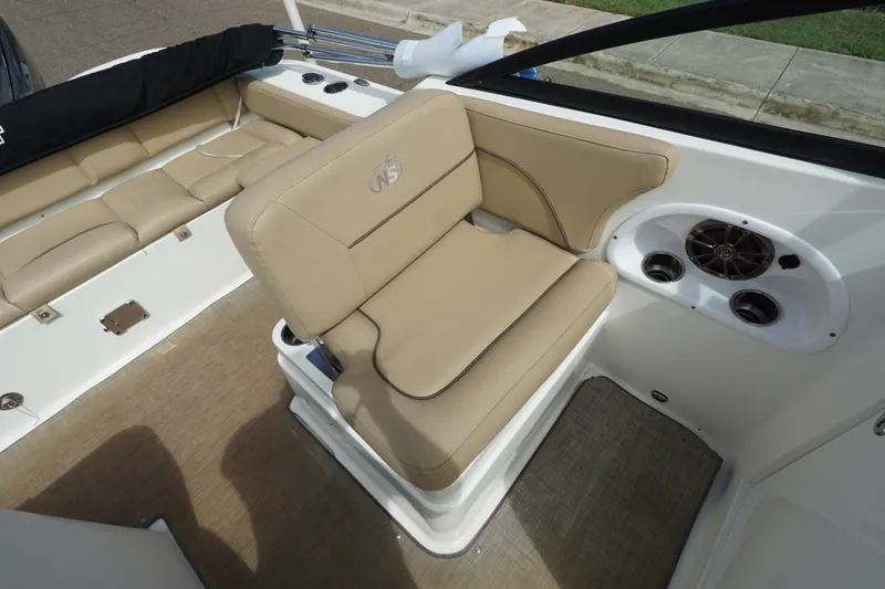 Slide: The Image of 2020 NauticStar 2302 Legacy Dual Console interior with beige seating and speaker system. - 16