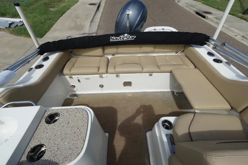 Slide: The Image of 2020 NauticStar 2302 Legacy Dual Console boat interior with beige seating and cup holders. - 17