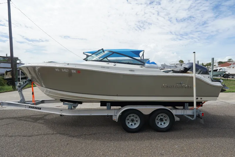 Slide: The Image of 2020 NauticStar 2302 Legacy Dual Console boat on trailer, side view. - 2