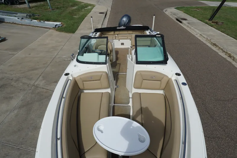 Slide: The Image of 2020 NauticStar 2302 Legacy Dual Console boat with tan seating and white table. - 13