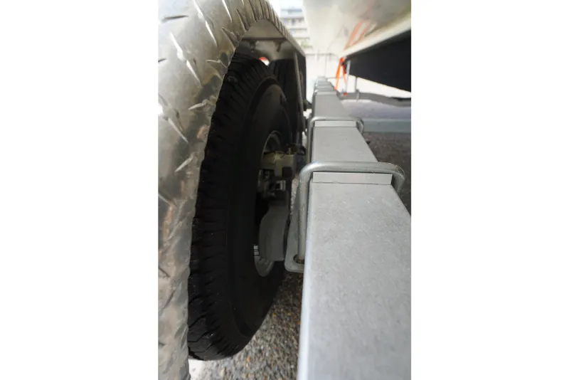 Slide: The Image of Close-up of a 2020 NauticStar 2302 Legacy trailer wheel and frame. - 9