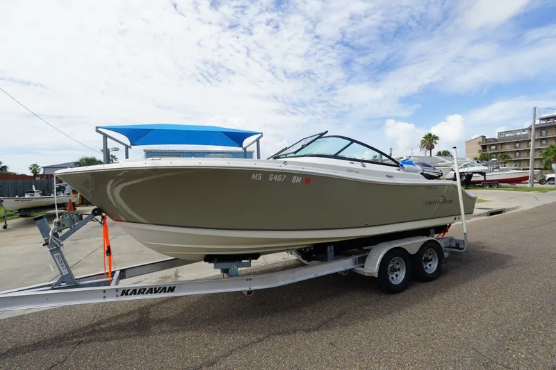 Slide: The Image of 2020 NauticStar 2302 Legacy Dual Console boat on trailer, parked outdoors. - 1