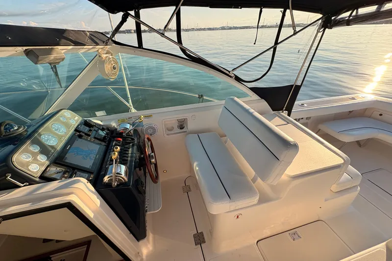 Slide: The Image of 2003 Tiara Yachts 2900 Coronet cockpit with helm, seating, and ocean view at sunset. - 42