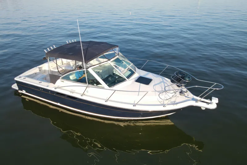 Slide: The Image of 2003 Tiara Yachts 2900 Coronet boat on calm water, featuring sleek design and canopy. - 16