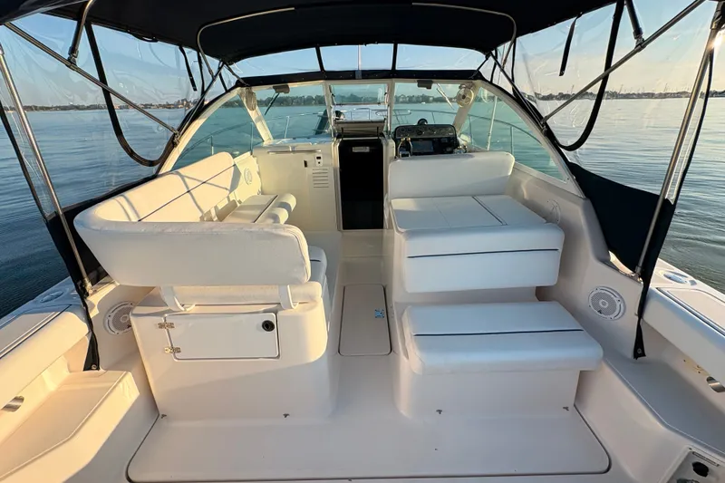 Slide: The Image of 2003 Tiara Yachts 2900 Coronet interior with white seating and helm, on calm water. - 40