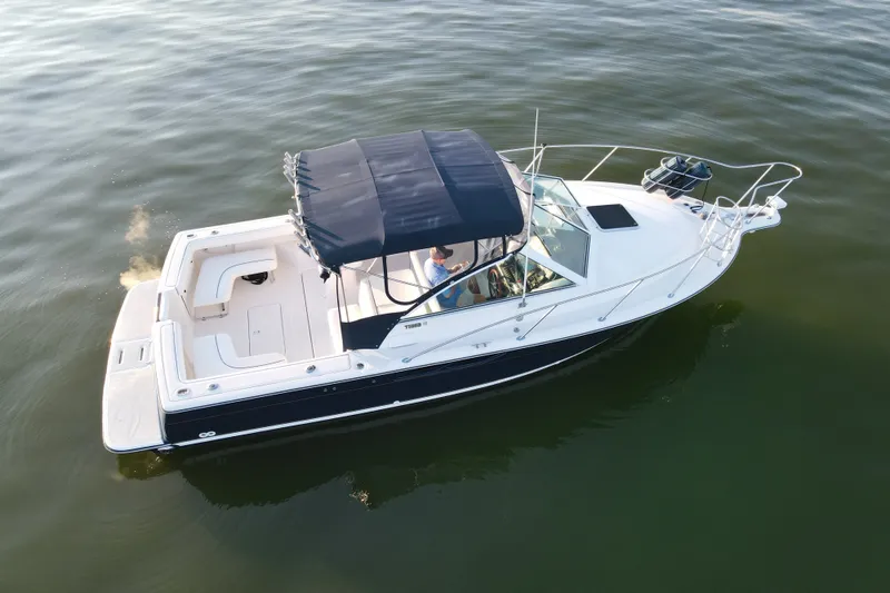 Slide: The Image of 2003 Tiara Yachts 2900 Coronet cruising on calm waters with a blue canopy. - 2