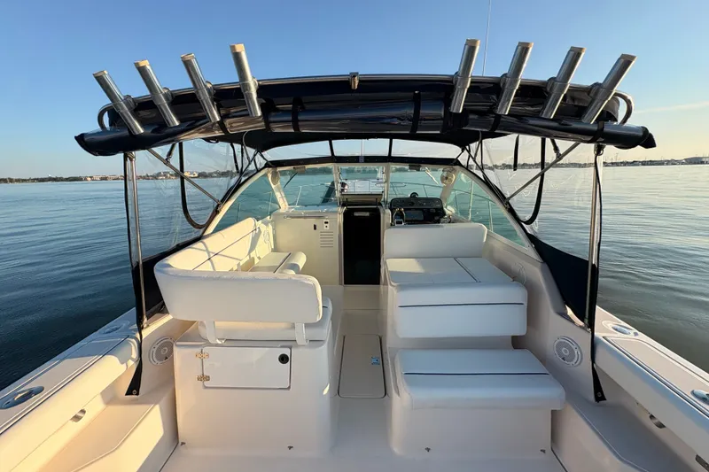 Slide: The Image of 2003 Tiara Yachts 2900 Coronet boat interior with seating and rod holders on calm water. - 39