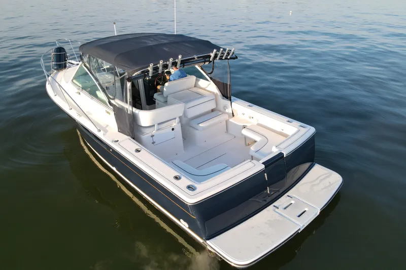 Slide: The Image of 2003 Tiara Yachts 2900 Coronet on calm water, featuring spacious deck and seating. - 11