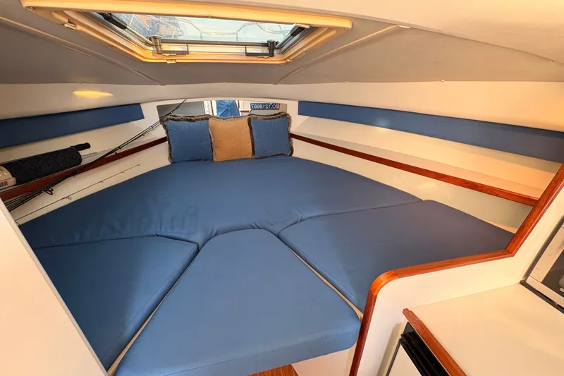 Slide: The Image of Cozy cabin interior of 2003 Tiara Yachts 2900 Coronet with blue cushions and wooden accents. - 53