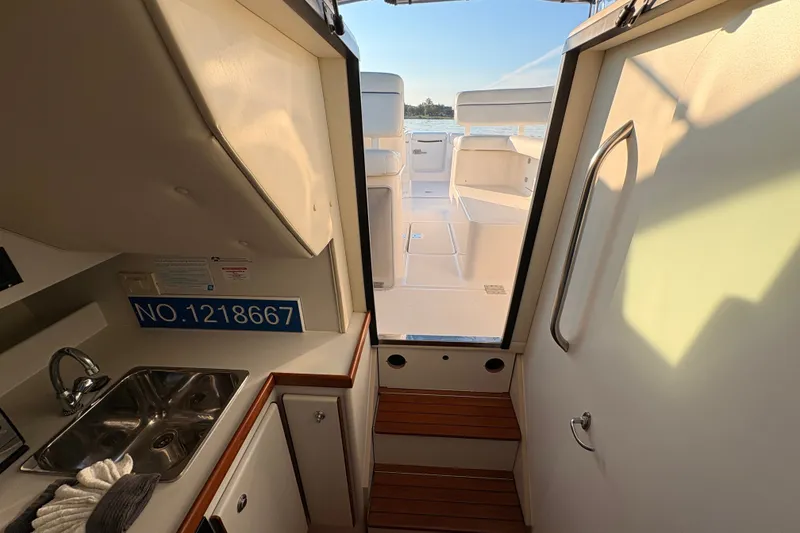 Slide: The Image of Interior view of 2003 Tiara Yachts 2900 Coronet, featuring a compact kitchenette and steps to deck. - 48