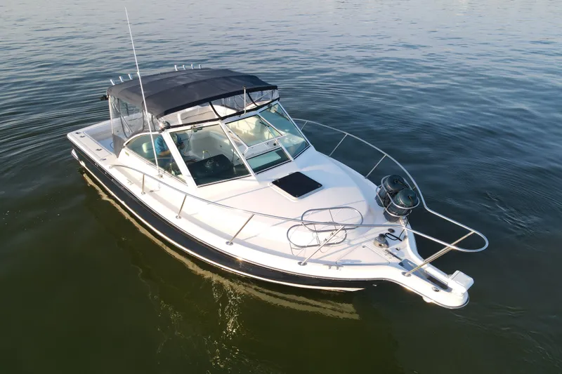 Slide: The Image of 2003 Tiara Yachts 2900 Coronet boat on calm water, featuring sleek design and canopy. - 14