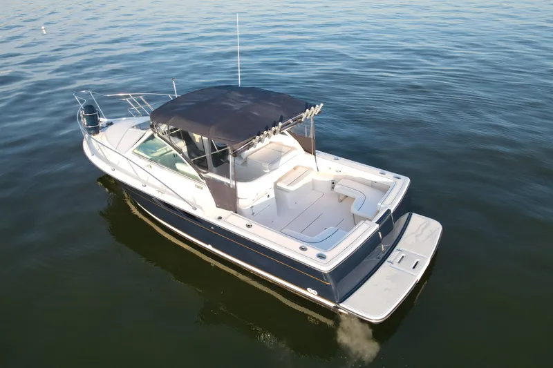 Slide: The Image of 2003 Tiara Yachts 2900 Coronet boat on calm water, featuring spacious deck and canopy. - 6