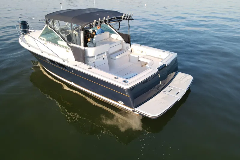 Slide: The Image of 2003 Tiara Yachts 2900 Coronet cruising on calm waters, featuring a sleek design and spacious deck. - 10