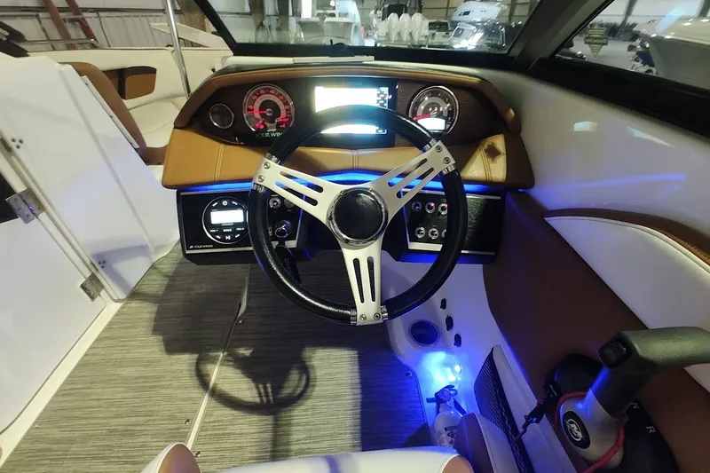 Slide: The Image of 2020 Four Winns HD220 boat dashboard with illuminated controls and steering wheel. - 17