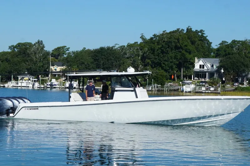 Slide: The Image of 2023 Contender 44 ST boat cruising on a calm lake with scenic background. - 6