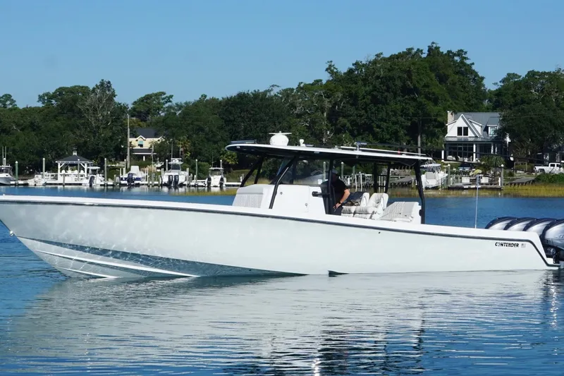 Slide: The Image of 2023 Contender 44 ST boat cruising on a calm lake with scenic background. - 9
