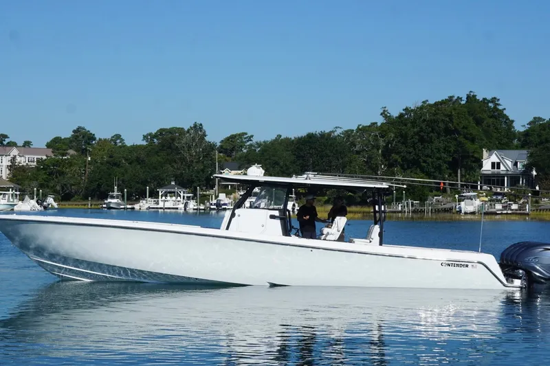 Slide: The Image of 2023 Contender 44 ST boat cruising on a calm lake with scenic background. - 12
