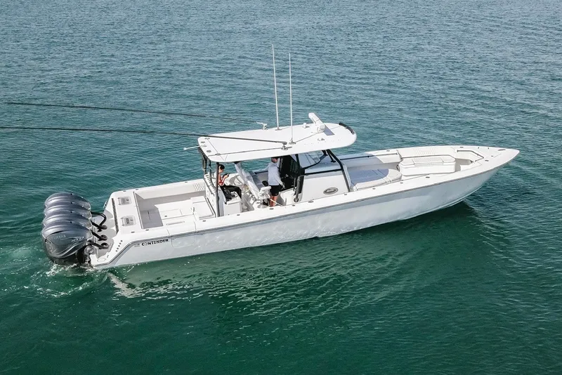 Slide: The Image of 2023 Contender 44 ST boat cruising on clear blue water with triple outboard engines. - 13