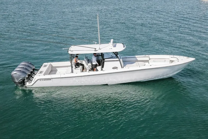 Slide: The Image of 2023 Contender 44 ST boat cruising on clear blue water with multiple outboard engines. - 4