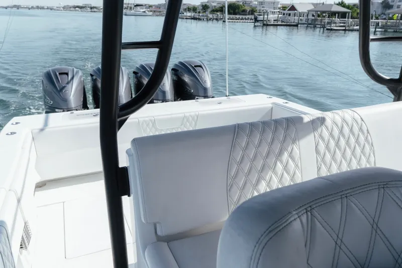 Slide: The Image of 2023 Contender 44 ST boat with quad engines, luxurious seating, and scenic waterfront view. - 25