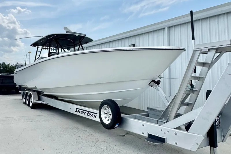Slide: The Image of 2023 Contender 44 ST boat on a Sport Trail trailer, parked outdoors. - 17