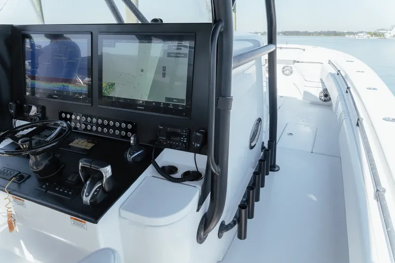 Slide: The Image of 2023 Contender 44 ST boat cockpit with dual navigation screens and steering wheel. - 21