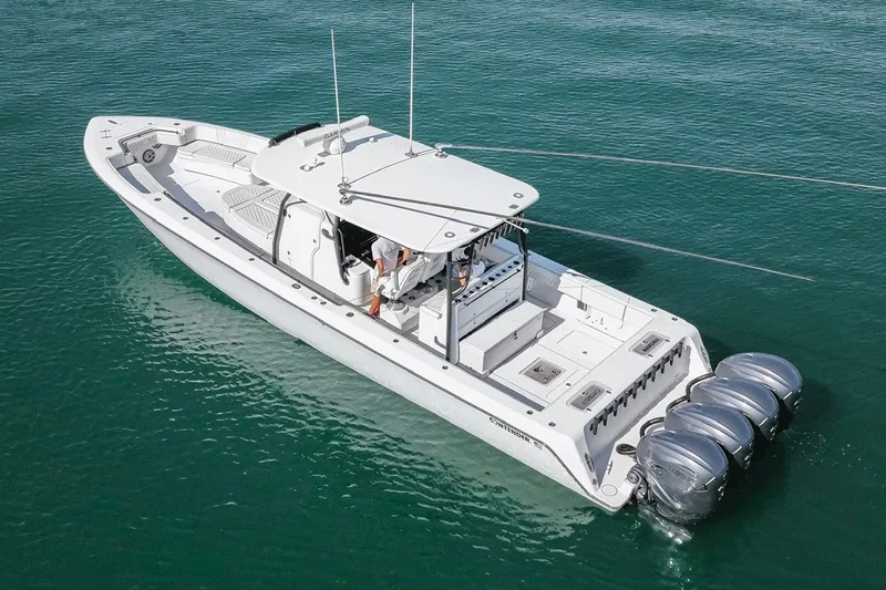 Slide: The Image of 2023 Contender 44 ST boat with triple outboard engines on clear water. - 3