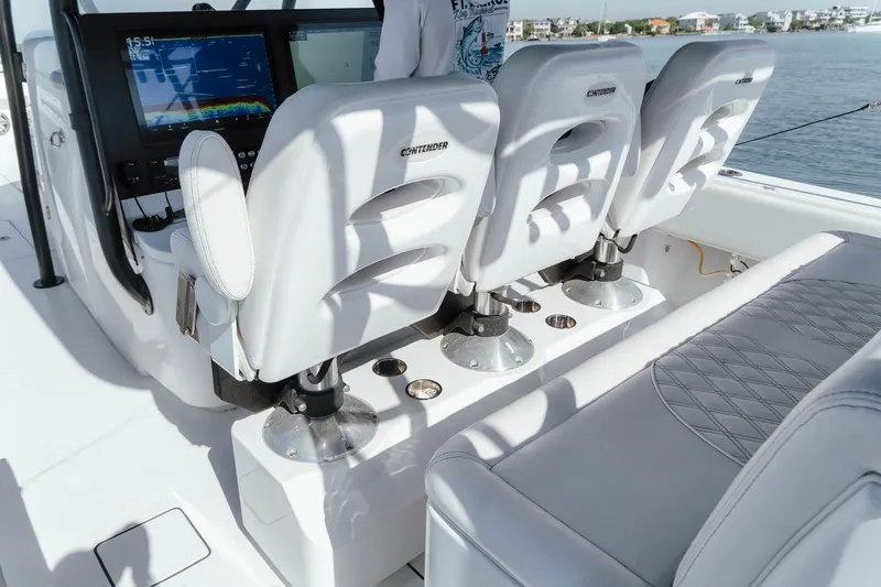 Slide: The Image of 2023 Contender 44 ST boat interior with white seating and advanced navigation display. - 24