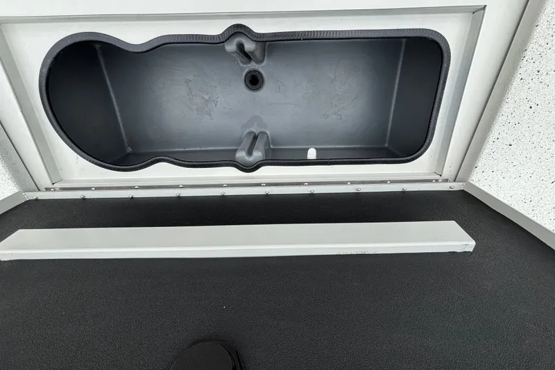 Slide: The Image of 2027 Ranger RB200 storage compartment with black interior and secure latch. - 15